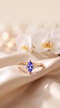Load image into Gallery viewer, MiShelli Tanzanite marquise ring with diamond accents in 14K gold, size 7, featuring a vibrant blue gemstone and sparkling detail.